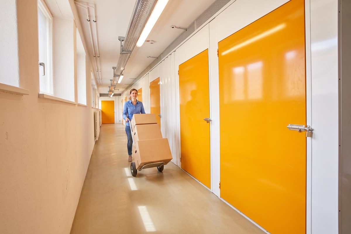 Heller Gang mit orangen Boxentüren im Selfstorage Urdorf